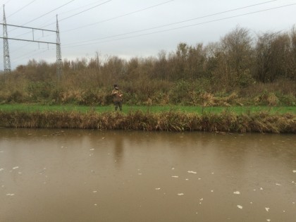 Ondanks het bruine water en inmiddels ook regen blijf Dick zijn lijntje werpen.