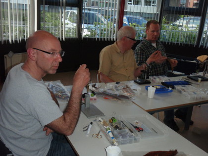 Klaas kijkt toe of Pierre het ribben van het lijfje goed doet.